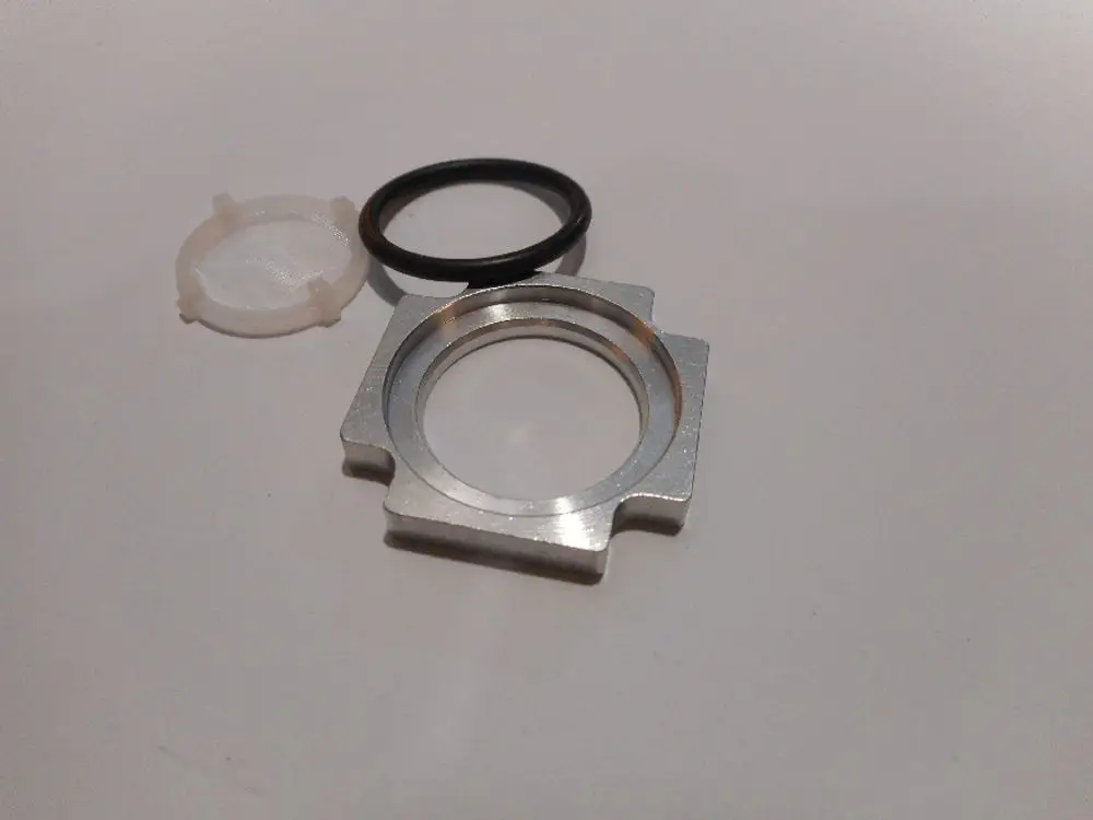 Siebfilter von Remeha, besteht aus einem Aluminium-Gehäuse, einem Gummi-O-Ring und einem Kunststoff-Filterelement. Die Teile sind in einer angeordneten Position abgebildet.